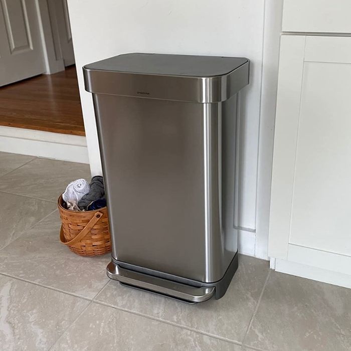 A reviewer's photo of the high-tech trash can placed in a kitchen.