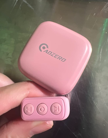 A reviewer holding the pink version of the remote control ring.