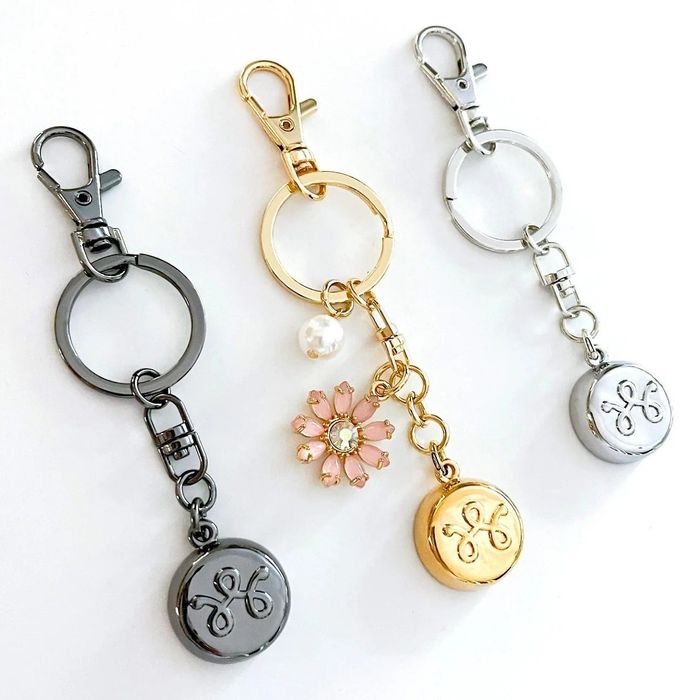 The keychain is available in black, gold, and silver