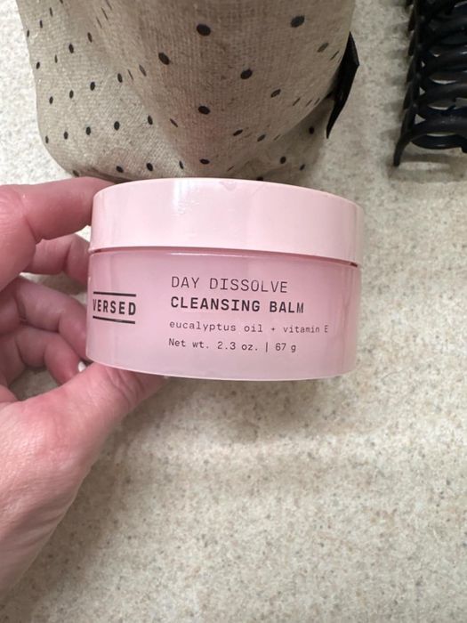 A hand holding a jar of Versed Daily Dissolve Cleansing Balm with eucalyptus oil and vitamin E, 2.3 oz (67g)