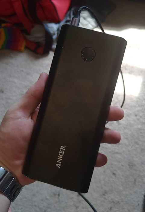 A reviewer holding the Anker PowerCore+ power bank.