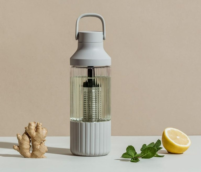The bottle featuring its built-in infusion chamber, filled with a colorful liquid.