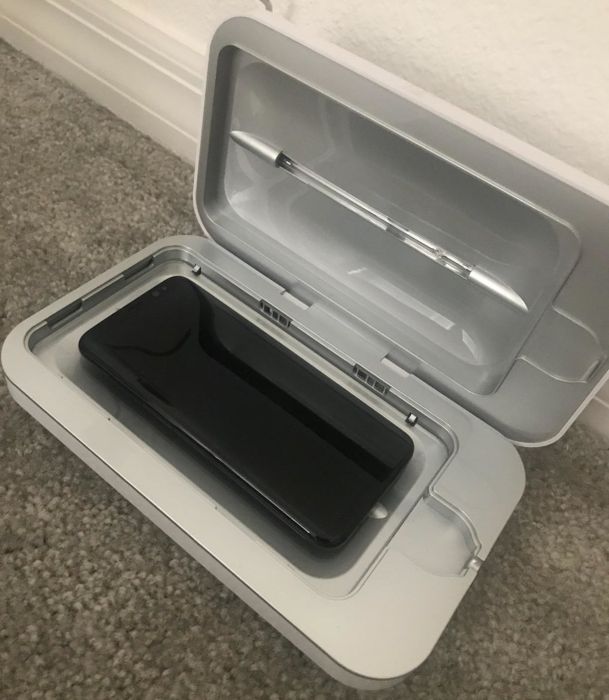 A photo of a reviewer showcasing the open phone sanitizer with a phone placed inside.