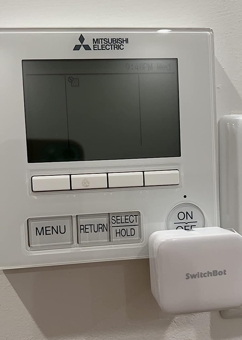 A reviewer photo of the SwitchBot installed on a thermostat.