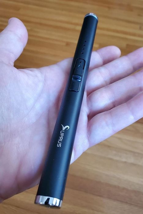 A reviewer holding the electric lighter in the palm of their hand.