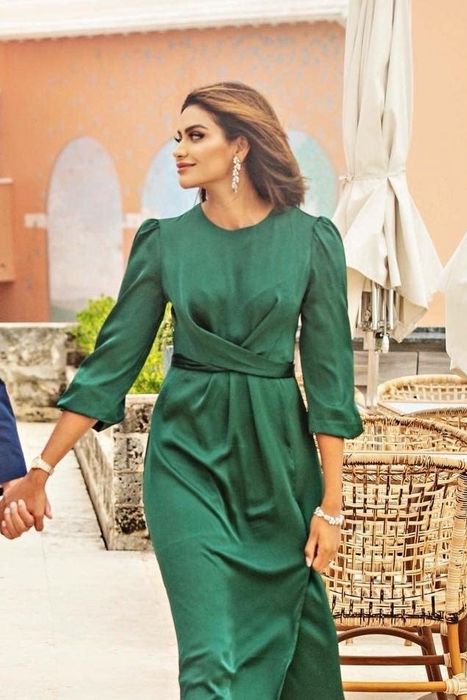 a reviewer wearing the green dress during a photoshoot
