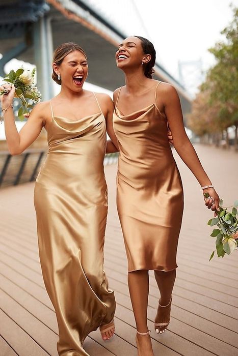 Two models showcasing beige cowl neck dresses, one in a midi and the other in a maxi length.