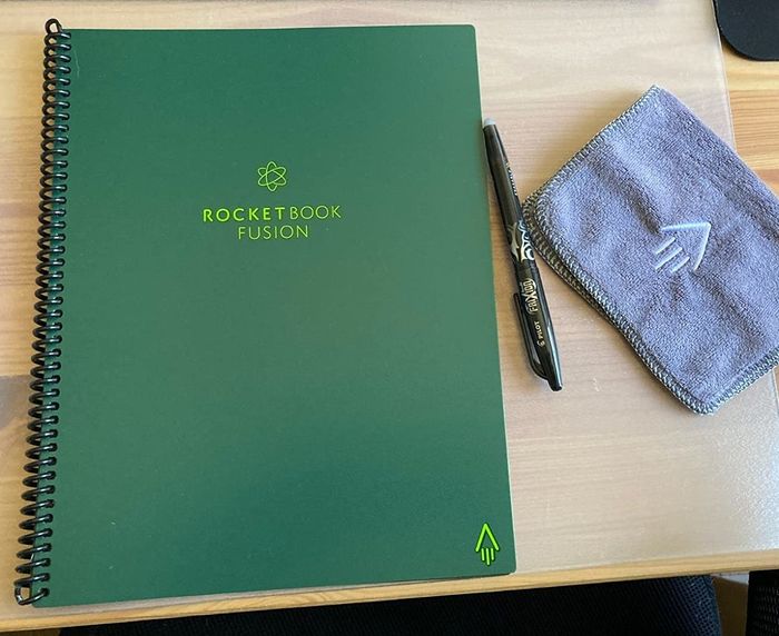 A reviewer's photo of the closed notebook, complete with the included pen and microfiber cloth