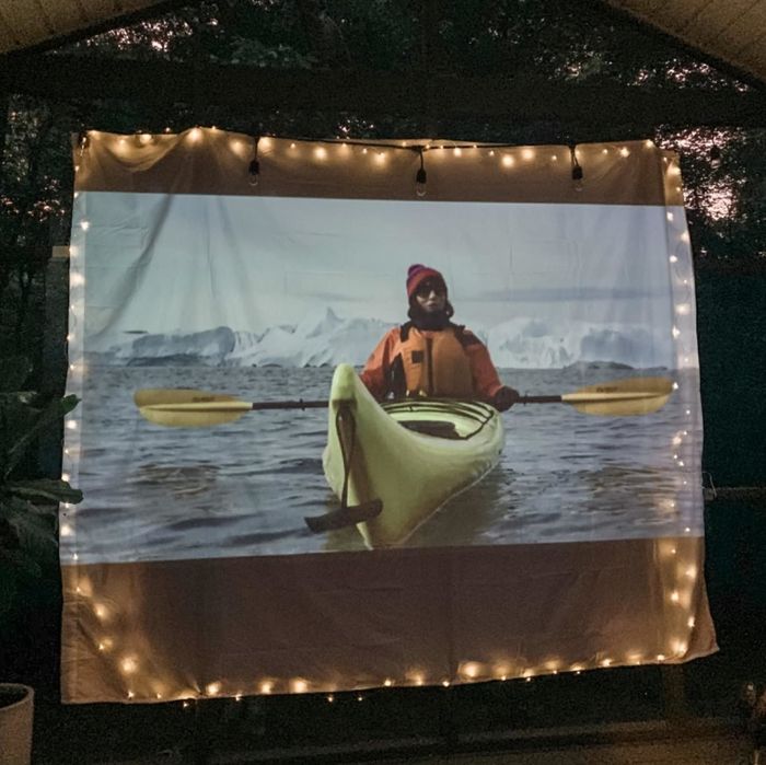 A reviewer's image of the projector casting a movie onto a white sheet