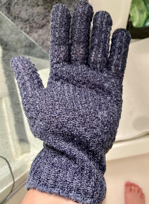 A reviewer is seen wearing a blue fingered glove while showering.