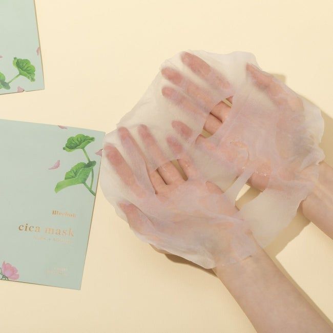 A model holding the sheet mask alongside its packaging.