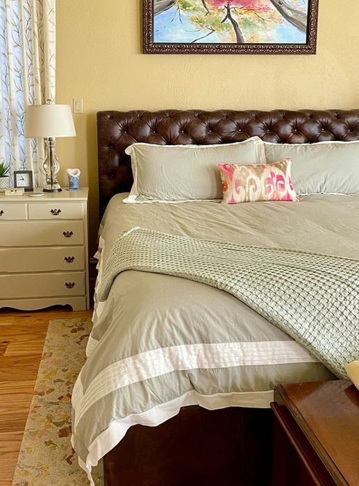 A reviewer’s image featuring the blanket draped over the corner of the bed.