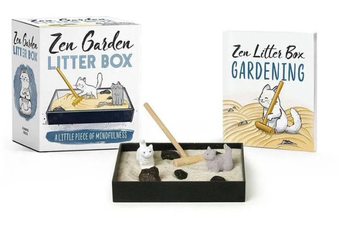 A tiny zen garden featuring a rake, two cats, sand, and rocks.