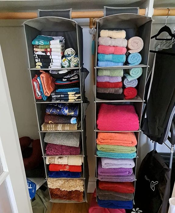 Reviewer photo of two closet organizers filled with clothes and towels.
