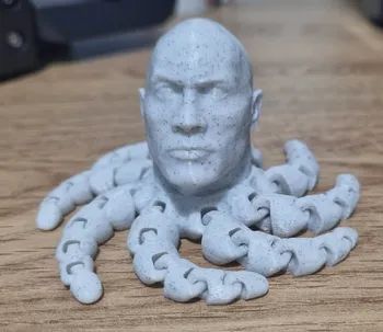 A grey Dwayne 'The Rock' Johnson/octopus fidget spinner.