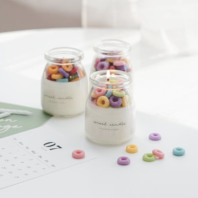 A petite milk jug-shaped candle with a colorful wax rainbow.