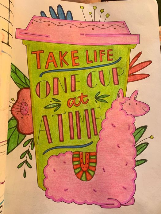 A reviewer's colored-in page showing a llama in front of a to-go coffee cup labeled with a recipe.