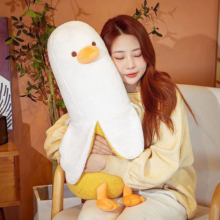A person embracing a giant banana duck plushie, adding a sense of fun and comfort.