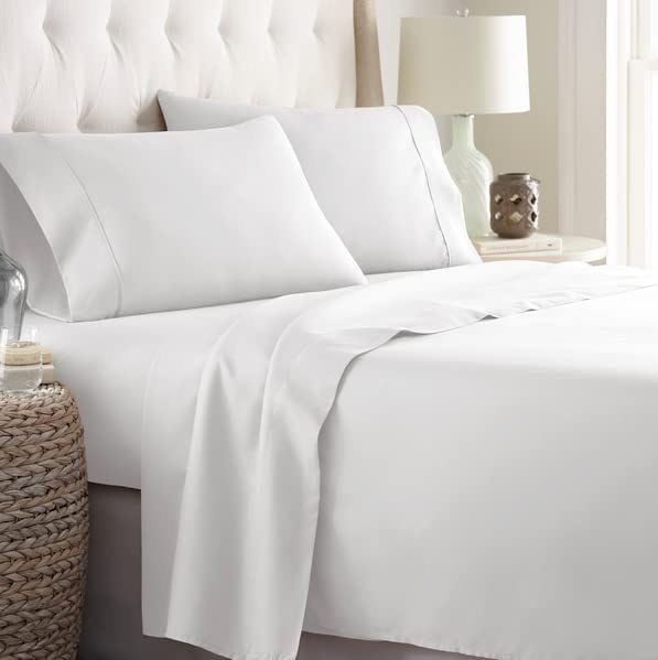 A close-up of the sheets spread out on a white bed.