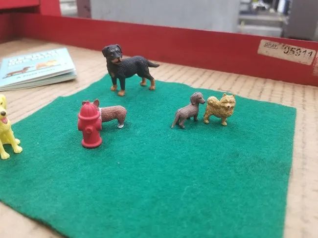 A green mat with toy dogs and a fire hydrant.