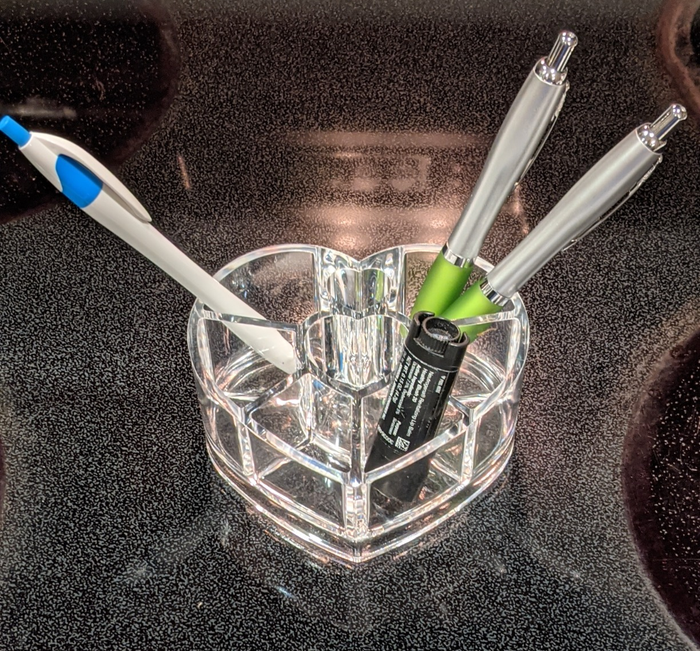 An organizer holding pens and lip balm