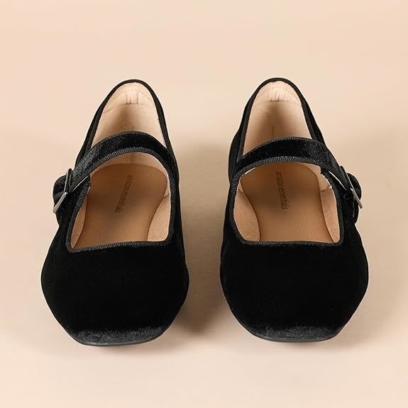 Pair of black velvet Mary Jane shoes featuring a single strap and buckle