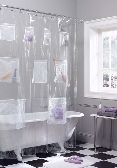 A clear shower liner with various items tucked into its pockets.