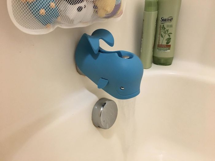 A reviewer’s photo showing the playful blue whale covering a bath faucet, adding both safety and charm to bath time.