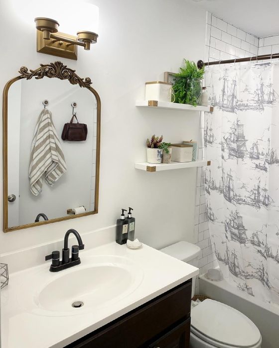 A gold-framed mirror placed in a reviewer’s bathroom space.
