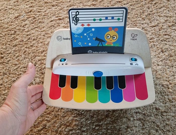 An image of a piano with a music note card placed inside.