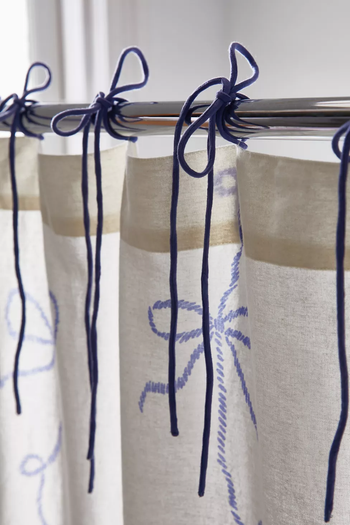 Dark blue bows adorning the top of the shower curtain.