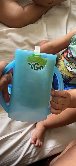 A reviewer’s photo showing them holding the pouch holder with a food pouch inside.
