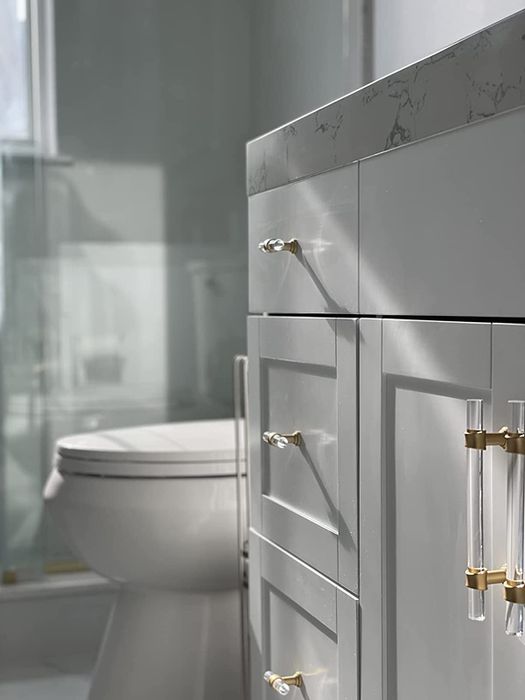 A reviewer's bathroom cabinets updated with chic acrylic and gold pulls, giving the space a polished and modern touch.