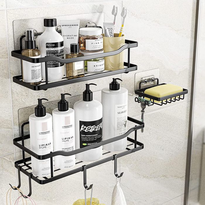 Three black shower caddies holding a variety of toiletries.