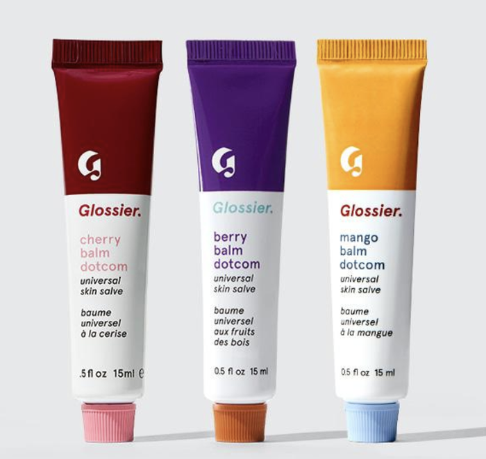 Three Glossier balms in berry, mango, and cherry flavors.