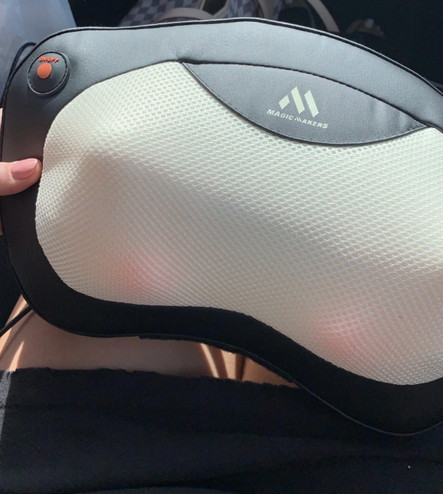 A reviewer showcasing the massager, featuring rotating heated balls under the fabric on both sides.