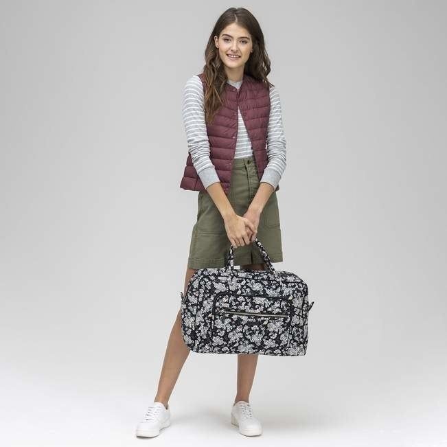 A model carrying the bag by the handles.