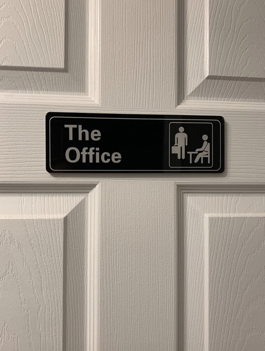 A small rectangular sign displayed by a reviewer, replicating the sign from The Office.