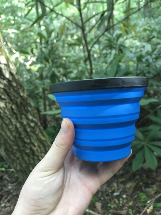 A writer holding a blue tiered MIG mug