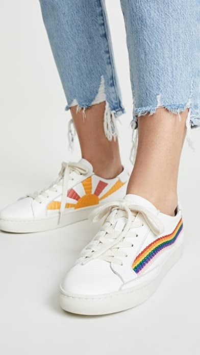 White sneakers with a rainbow embroidery along the outsides and a sun embroidered in yellow and orange along the insides