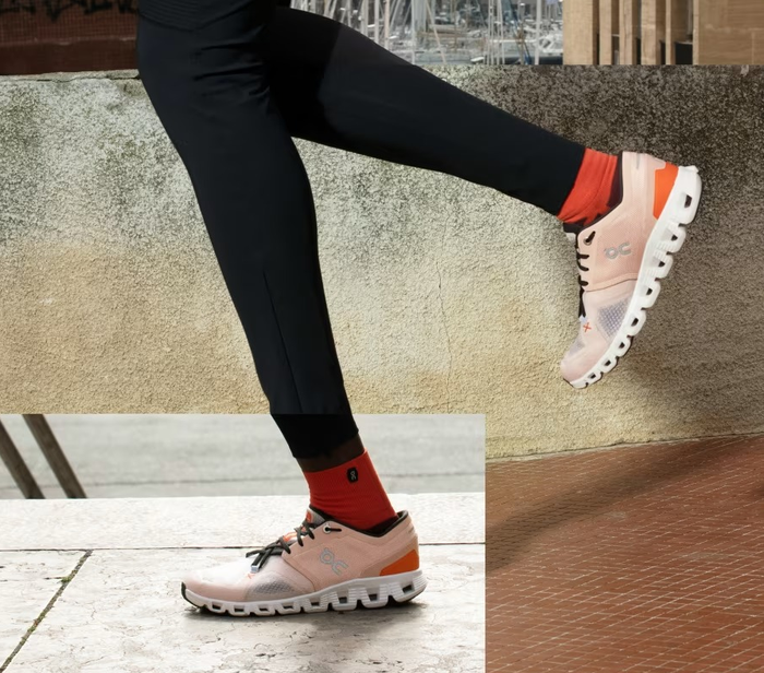 Model wearing the shoes in a soft light orange hue