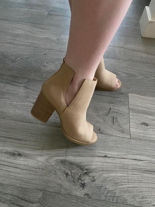 The reviewer is showcasing the shoes in a light brown shade.