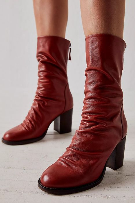 A model styling the boots in cinder red color