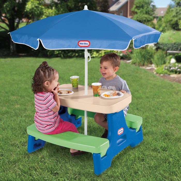 Two toddlers sitting at the picnic table.