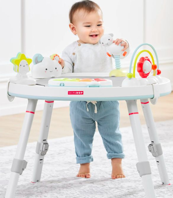 A baby standing at the activity center.