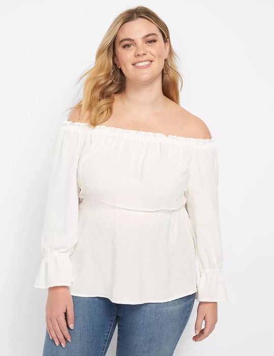 Model wearing an off-the-shoulder long white top paired with blue jeans