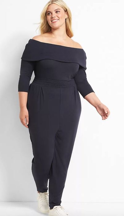 Model wearing a blue/black jumpsuit paired with sneakers