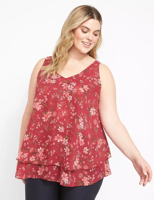 Model wearing a red, pink, white, and green floral print tank top paired with black pants
