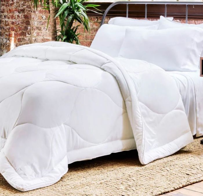 A soft, plush white comforter on a bed.