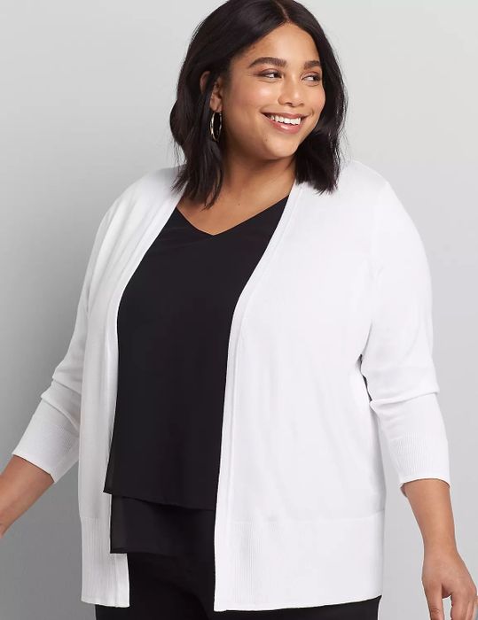 Model layered in a white cardigan over a black top and black pants
